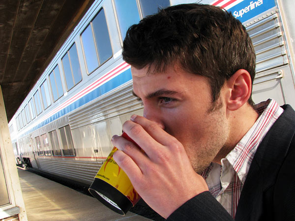 Micah sips from a cup of coffee, freshly arrived via Amtrak